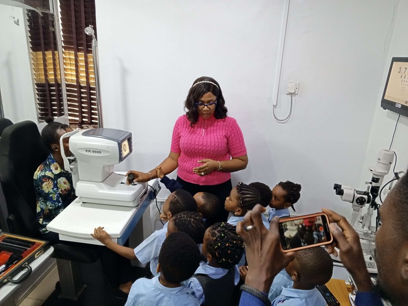 Dr Sheila showing school children on an excursion the autorefractor